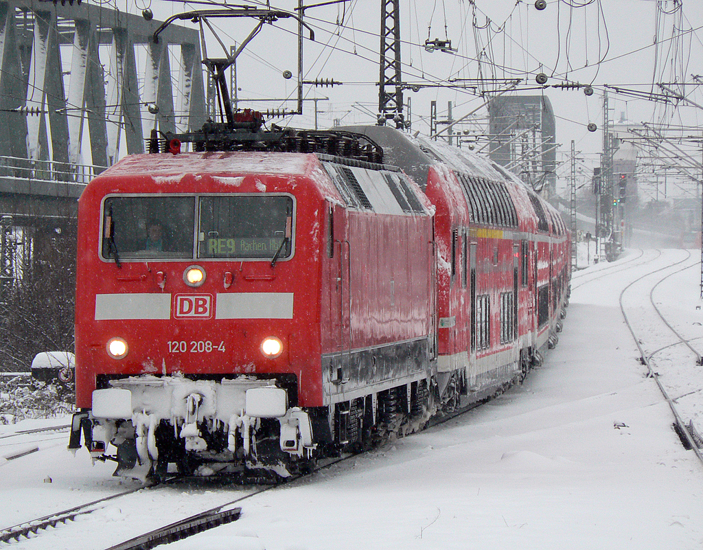 120 208-4 mit dem RE9/RSX nach Aachen Hbf, geschoben von 120 206-8, im winterlichen K�ln Messe/Deutz am 24.12.2010